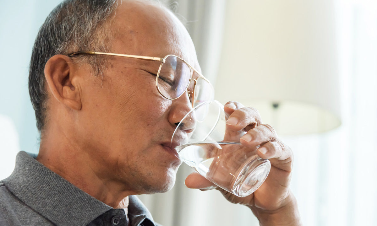 A senior man drinking a glass of water