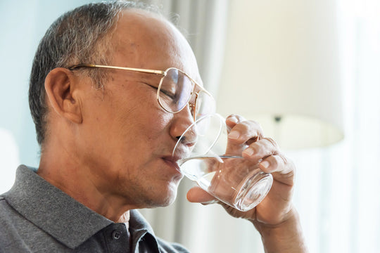 A senior man drinking a glass of water